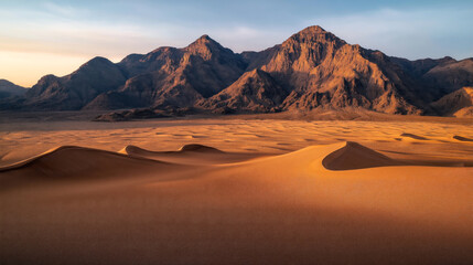 Naklejka premium Scenic view of desert landscape with sand dunes in foreground and mountain range in background under clear sky at sunset