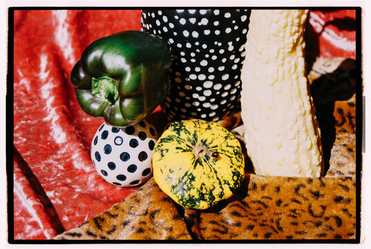 Colorful vegetables and patterned objects arranged on textured fabric