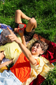Children Relaxing and Making Music in Grass