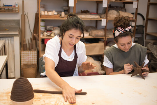 Two friends taking a sculpture class together