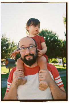 Cute moment of father with little doughter on his shoulders