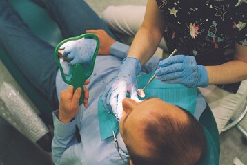 Dentist show to male patient the problem  teeth while consultation.