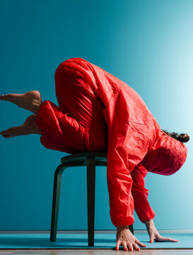 Person in Red Suit Performing Chair Yoga Balance Pose