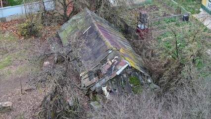 An ancient dwelling house burrowed into the ground. Home of the homeless. A house to be demolished. A barn, animal pen with a patched, hole in the roof. Abandoned estate, plot, land, garden.