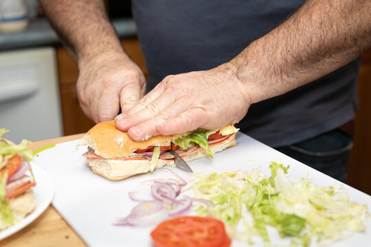 Closeup of hands cutting and making a fresh sub sandwich