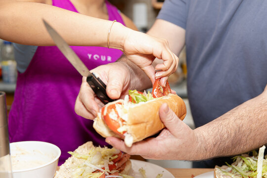 Closeup image of a pair of hands making fresh sub sandwich