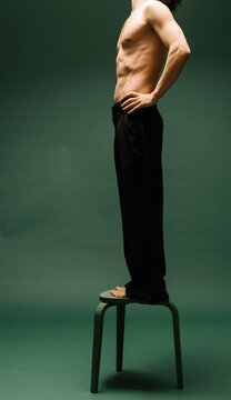 Side View of Shirtless Man Standing on a Stool