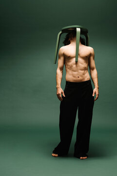 Creative Portrait of Man Balancing a Chair on His Head