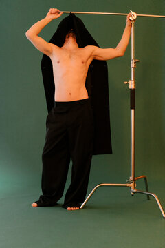 Man Posing in Studio with Jacket Over Head