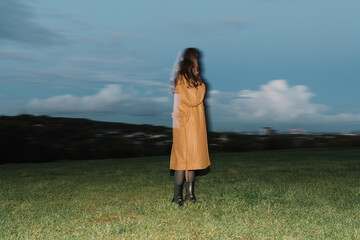Blurred Woman Standing in a Field with Overcast Sky