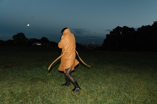 Woman Walking Alone at Night in a Field with Moonlight