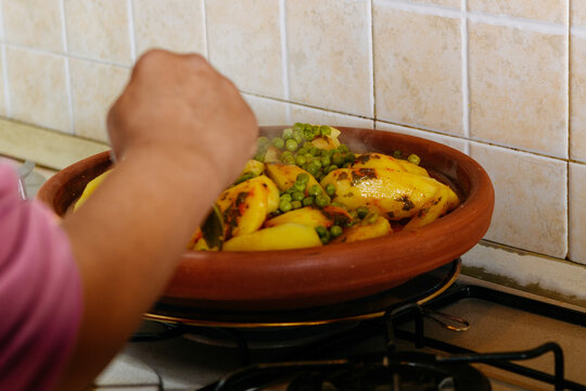 Female hand with a spoon ready to taste a traditional moroccan Tajine