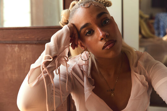 Woman with Blonde Braided Hair in Thoughtful Pose
