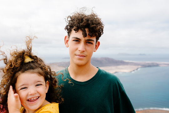 Mid-range shot of little girl posing with her brother at a viewpoint