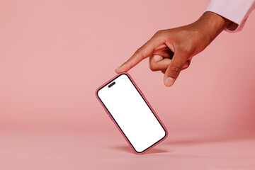 Person pointing at smartphone with blank screen on pink background