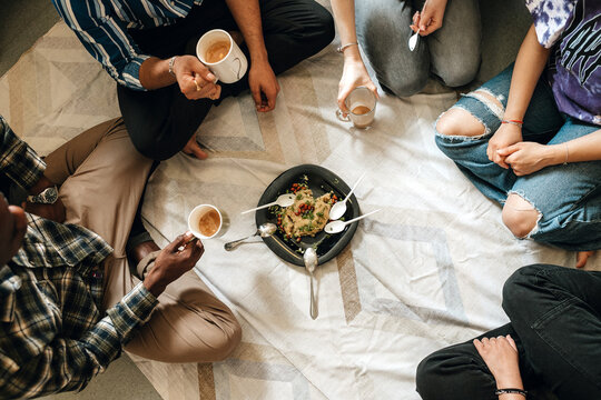 Multiracial students eating upma at the hostel room together.