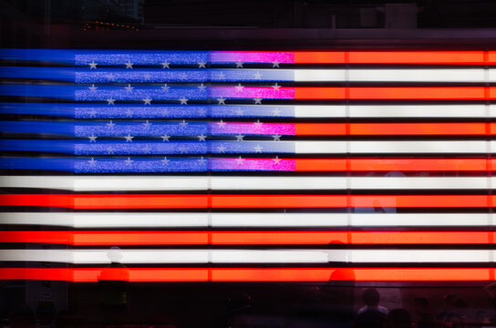 Reflection of American flag at night in New York City Times Square