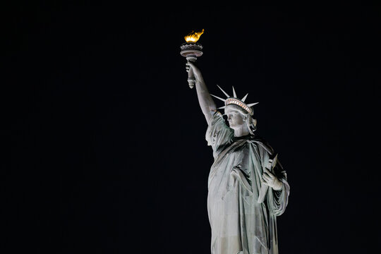 The Statue of Liberty illuminated at night in New York City skyline