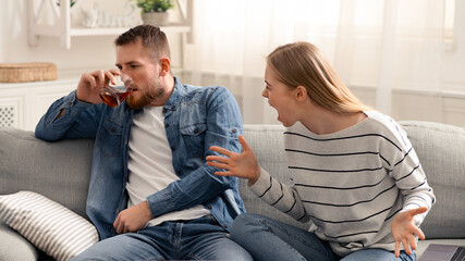 Drinking problem. Desperate woman arguing with drunk husband at home