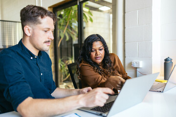 Coworkers helping each other with a shared project