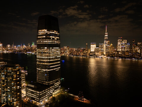 Waterfront Skyscraper and Illuminated City Skyline at Night
