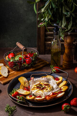 Baked camembert with strawberries, honey, rosemary and toasted bread