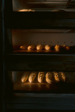 Multiple loaves of bread baking in stacked ovens.