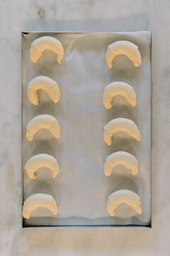 Unbaked croissants laid out on parchment paper.