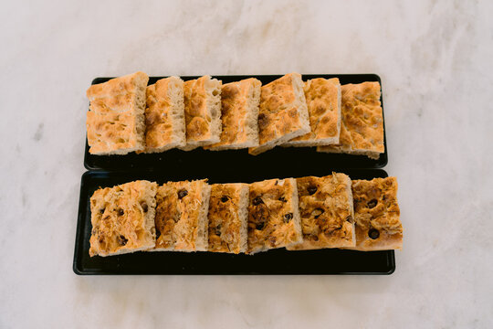 Loaf style focaccia bread served on black trays