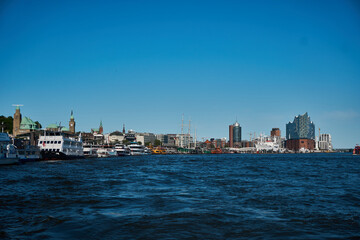 Fototapeta premium Cityscape along the waterfront with boats and modern architecture under a clear blue sky