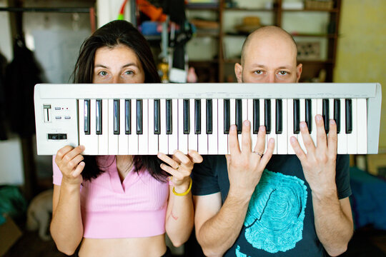 a man and a woman play a synthesizer