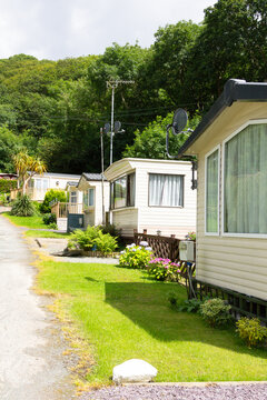 Row of static caravans, mobile homes in countryside setting on a summers day, A caravan park an escape from reality where people come to relax and unwind.