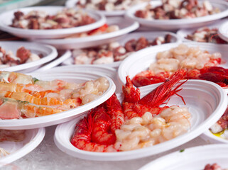 Fresh seafood served on plastic plates selective photo. Street market in Catania, Sicily. 