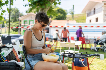 Smiling woman peeling potatoes at a neighborhood party