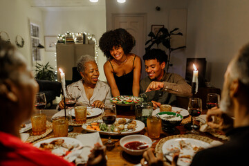 Family enjoying dinner together around table with candles