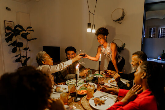 Happy family sharing thanksgiving dinner toasting with red wine