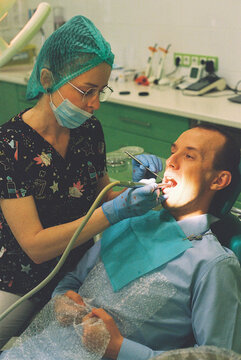 Dentist treats the patient's teeth, puts in a filling.