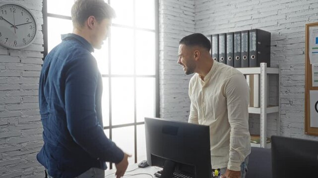 Men arguing in modern office with computer on desk amid tense discussion engaged employees focused on work-related conflict