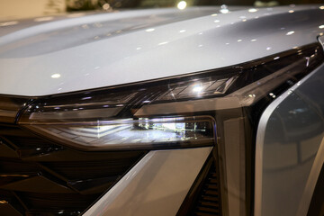 Fototapeta premium Close up of a cars headlight, part of automotive design