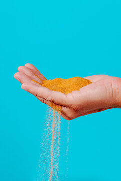 the sand slipes through the fingers of a man