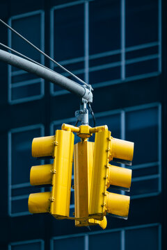 Iconic yellow traffic light against a modern building in New York