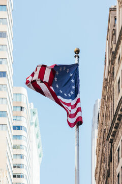 Betsy Ross flag waving in New York City amongst skyscrapers
