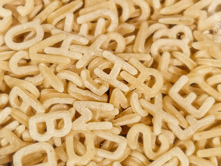 Alphabet letters from dough, pasta background from letters