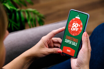 Christmas sale. Woman with a mobile phone and a sale advertisement. Marketing, advertising of...