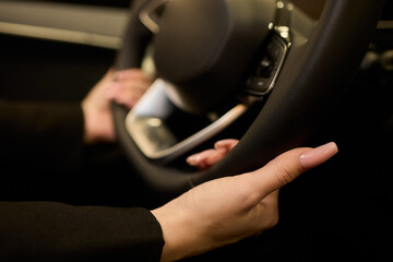 An up close image of a hand precisely adjusting a control in a luxurious automobile interior