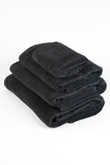 Black towels in a stack.Towel on a white background. Cotton fabric.