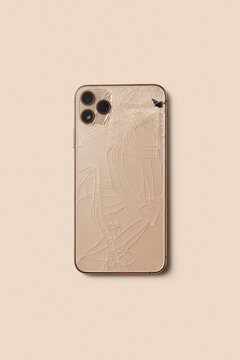 Desert titanium smartphone with cracked case and triple camera