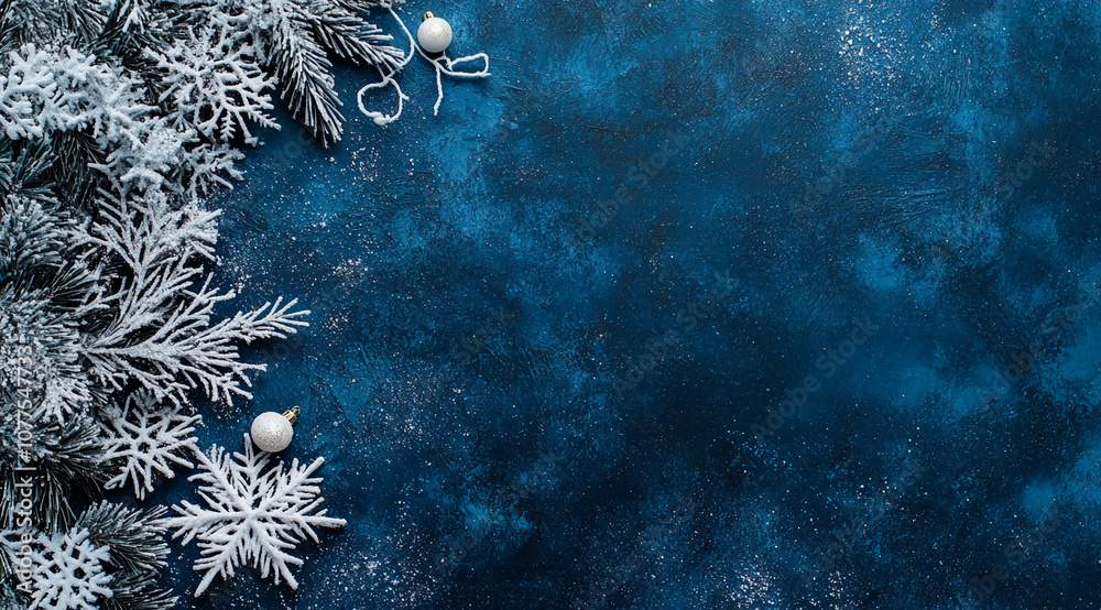 Poster white frosted pine branches and ornaments are arranged on a blue background, creating a festive wint