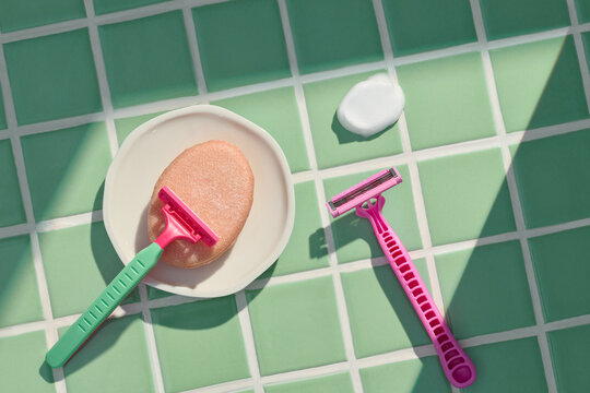 Razor and Soap with Foam on Green Tiled Bathroom Floor