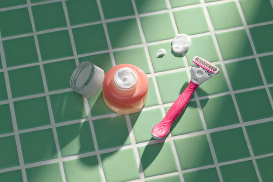Razor With Shaving Cream On Green Tiled Surface
